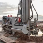 Drilling rig on muddy oilfield site with cementing equipment, illustrating conditions where cement accelerators improve early strength and reduce downtime.