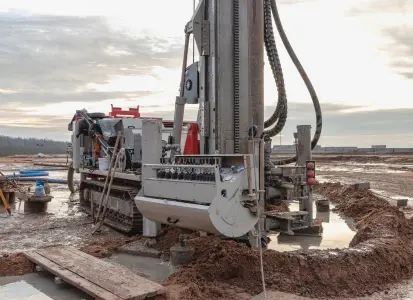 Drilling rig on muddy oilfield site with cementing equipment, illustrating conditions where cement accelerators improve early strength and reduce downtime.