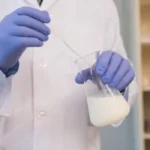 Lab technician preparing defoamer solution for oilfield cementing slurry stabilization